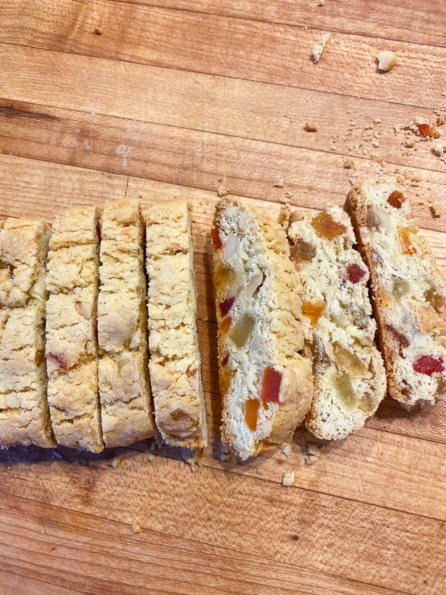 cutting tropical biscotti into individual pieces on wooden surface
