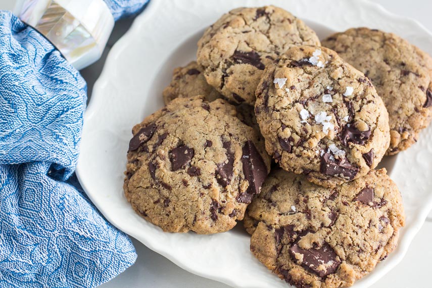 low FODMAP vegan chocolate chunk cookies on white plate with blue patterned napkin