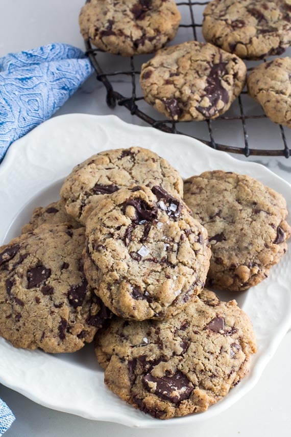 vertical image of low FODMAP vegan chocolate chunks cookies, one of them sprinkled with salt