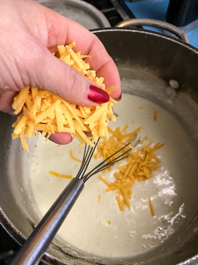 Adding cheddar cheese to the creamy roux to make sauce for low FODMAP mac and cheese
