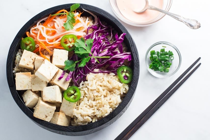 Banh mi tofu bowl without sauce in dark bowl; sauce alongside