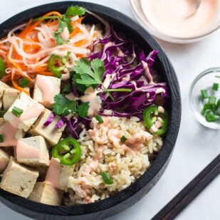 Banh mi tofu brown rice bowl in dark wooden bowl_