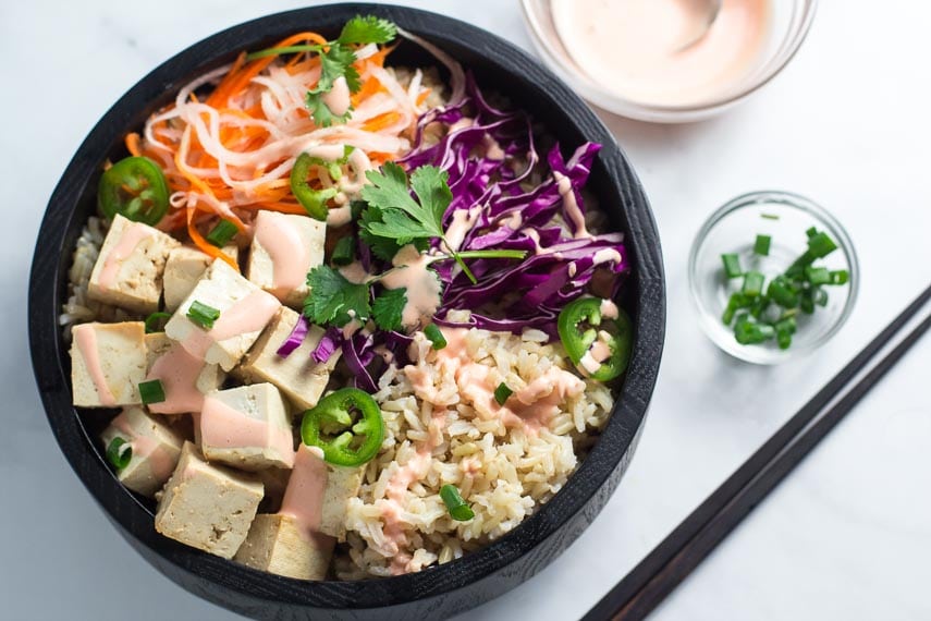 Banh mi tofu brown rice bowl in dark wooden bowl_