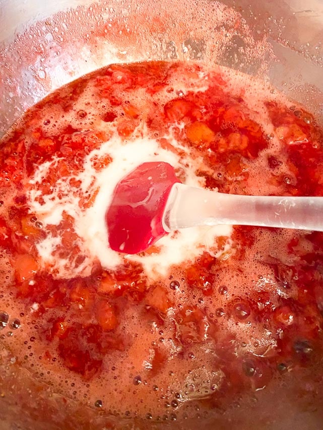 Cooked down strawberries and sugar in saucepan; stirring in cornstarch slurry