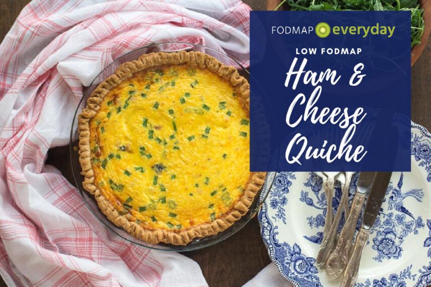 overhead image of ham & cheese low FODMAP quiche, whole, in pie pan with blue and white plates alongside