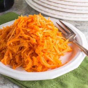 Low FODMAP Grated Carrot Salad on white plate; green napkin underneath, white plates alongside-2