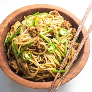 Low FODMAP Pork and Noodles in wooden bowl with chopsticks