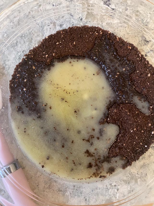 combining chocolate cookie crumbs and melted butter for a chocolate cookie press-in crust