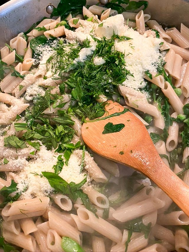 low FODMAP Pasta Primavera cooking; adding butter, cheese and herbs