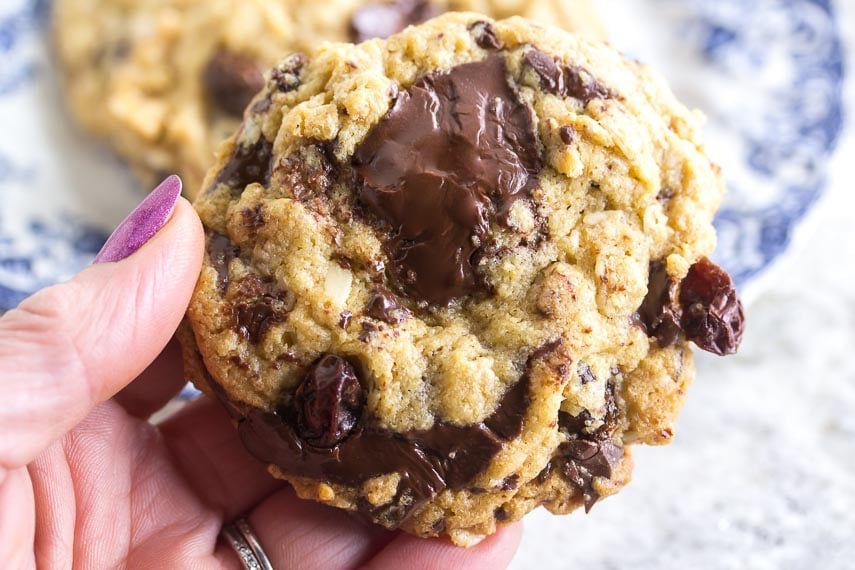 one bowl low FODMAP peanut butter chocolate chunk cookies held in hand. These are easy-to-make gluten-free Christmas cookies.