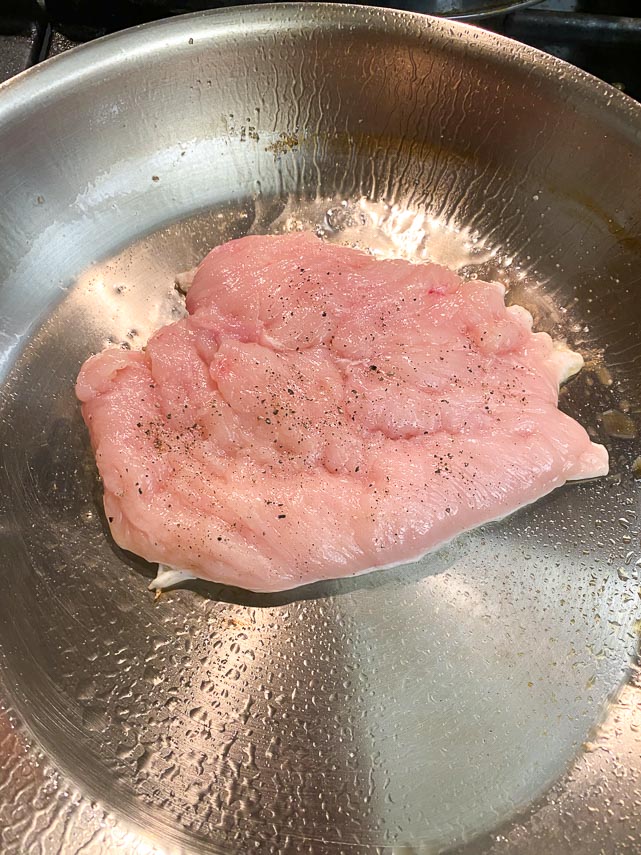 pan lightly coated with oil, chicken paillard cooking on first side