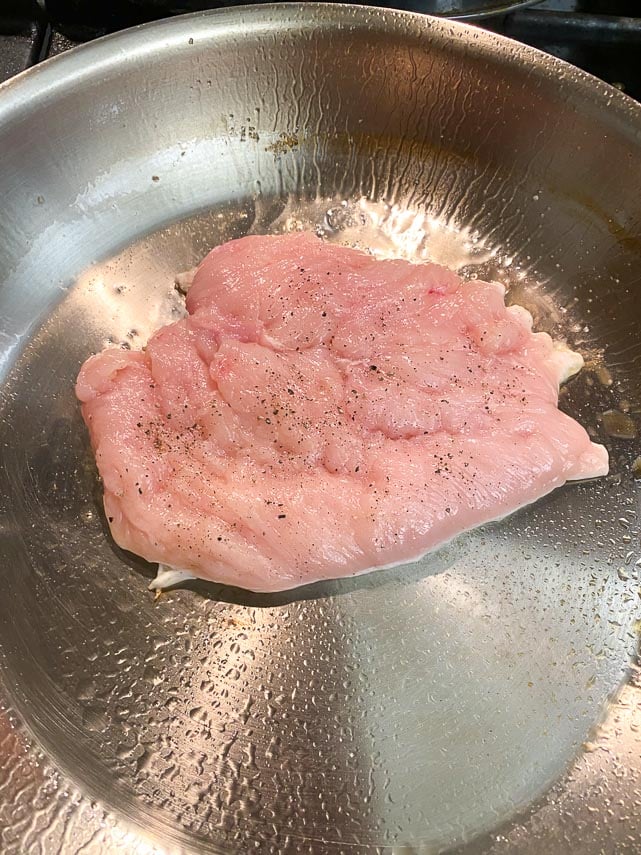 pan lightly coated with oil, chicken paillard cooking on first side