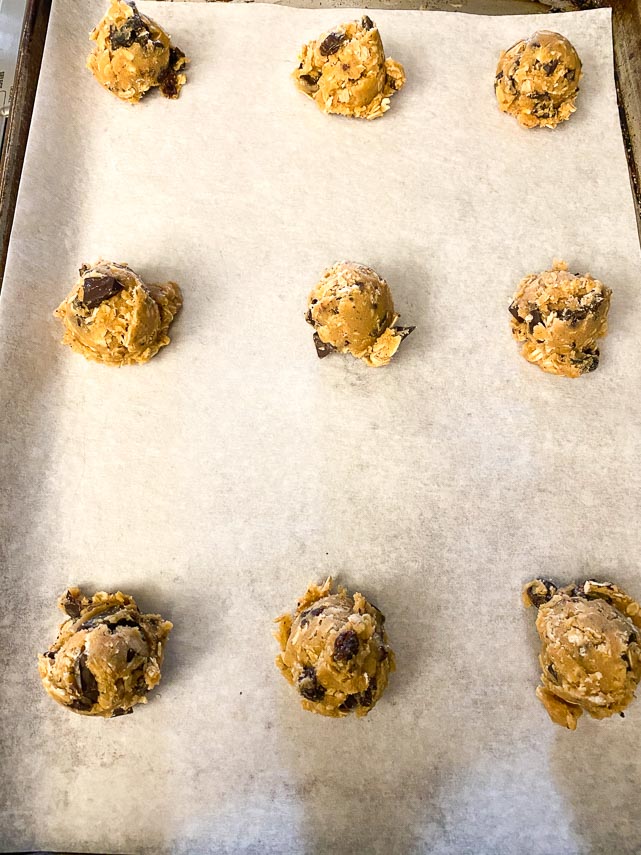 use a cookie scoop to portion out cookie dough onto sheet pans for one-bowl low FODMAP peanut butter oatmeal chocolate chunk cookies