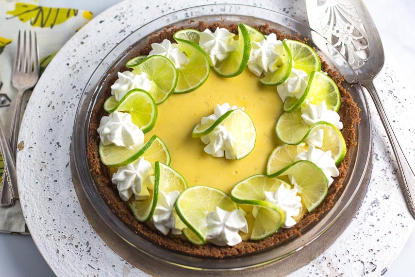 Overhead key lime pie in dish with silver server