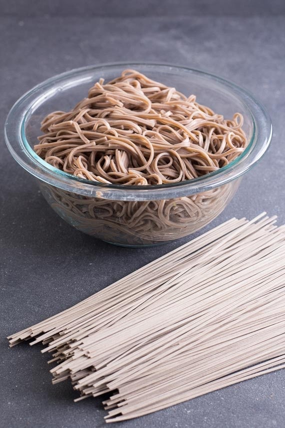 cooked and uncooked soba on dark surface