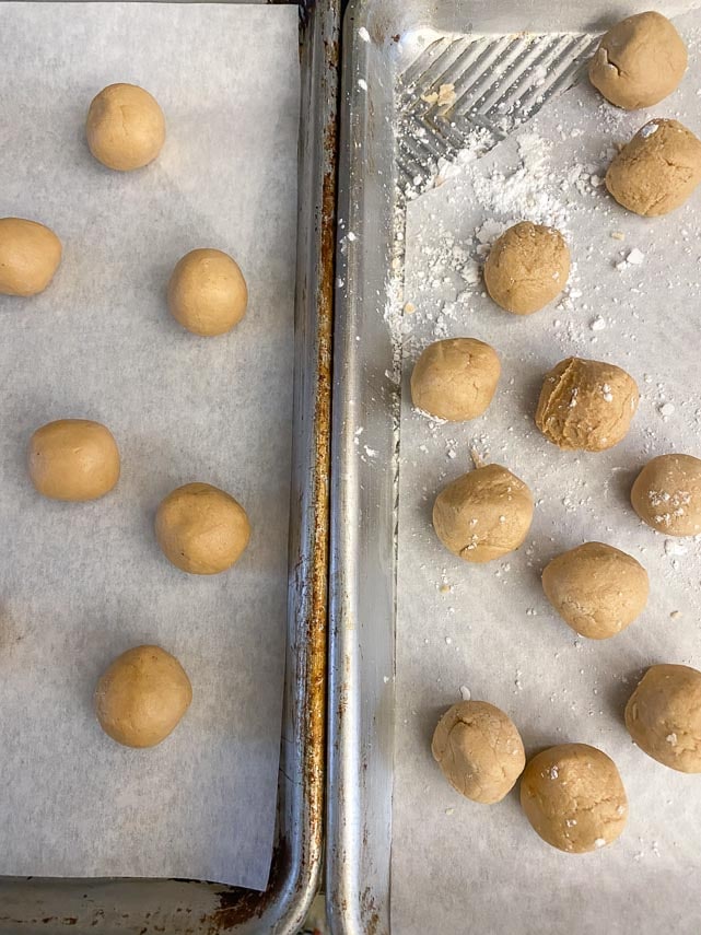 low FODMAP Buckeyes being rolled into balls on parchment lined trays