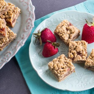 main image of for Nutty Low FODMAP Strawberry Oat Bars on aqua plate and napkin