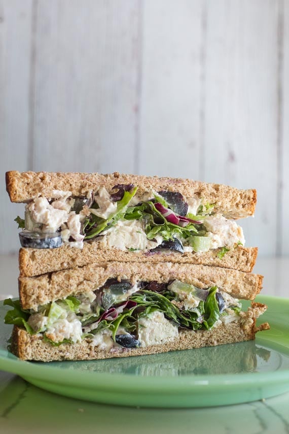 Low FODMAP Chicken Salad with Grapes and Almonds as a sandwich, cut into half, on a green plate