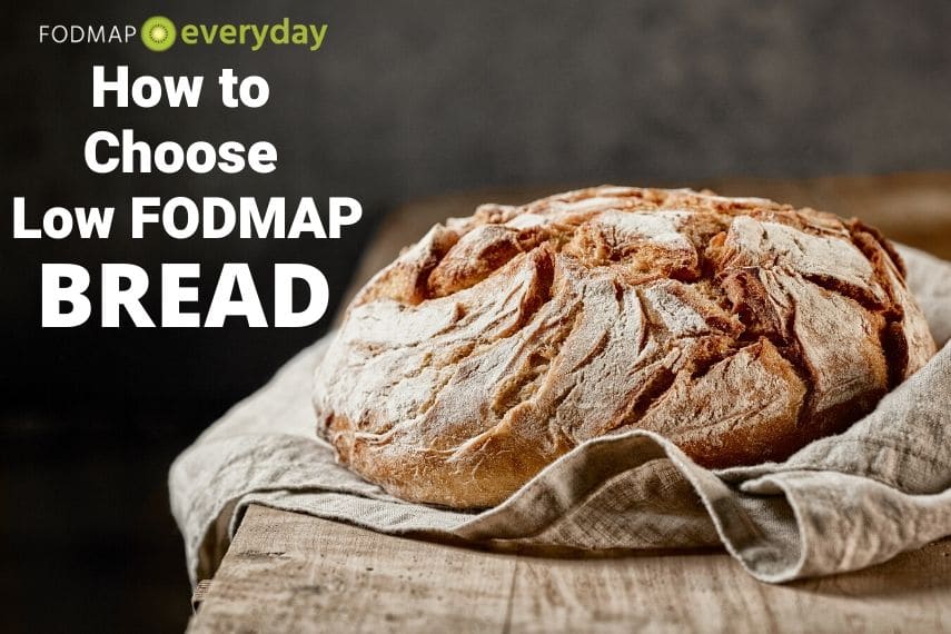 A freshly baked loaf of sourdough bread on top of a wooden counter