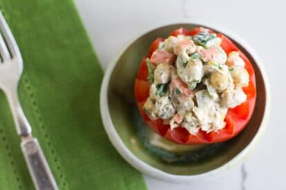 Overhead image of vegan low FODMAP CHICKPEA Salad stuffed into a tomato; green napkin
