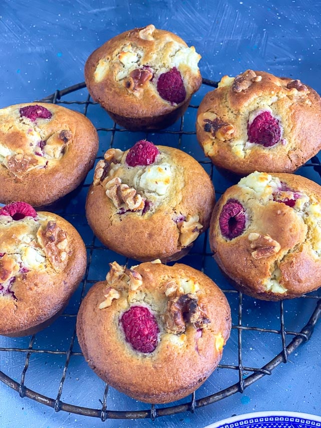 closeup of Low FODMAP Olive Oil Muffins with Goat Cheese, Walnuts and Raspberries in a round antique cooling rack;