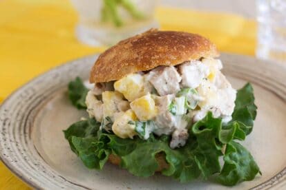 low FODMAP Pineapple Chicken salad on a roll with yellow napkin in background