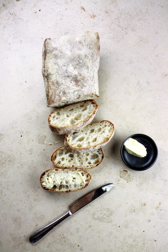 loaf of artisan bread on light background, sliced