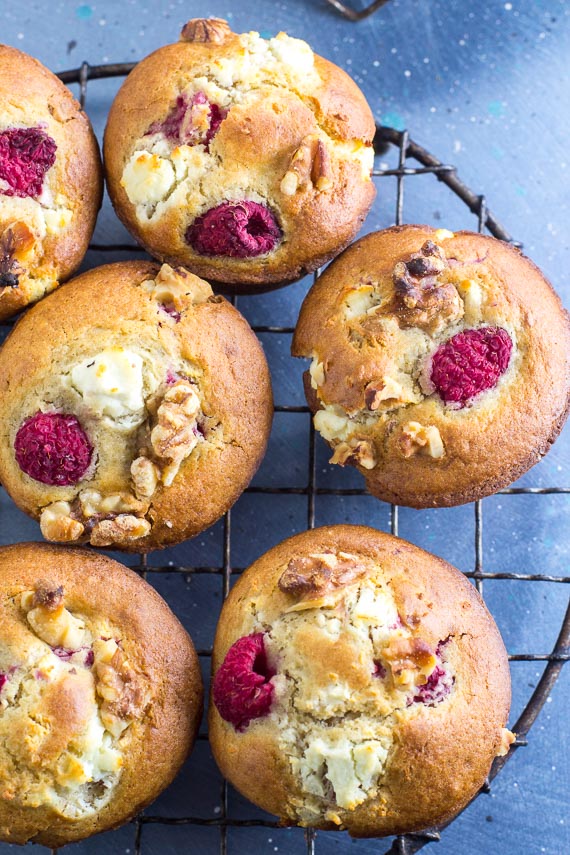 vertical overhead of Low FODMAP Olive Oil Muffins with Goat Cheese, Walnuts and Raspberries in a round antique cooling rack