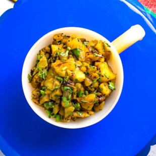 Horizontal image of Low FODMAP Grilled Pineapple & Kiwi Salsa in round handled dish on blue tray