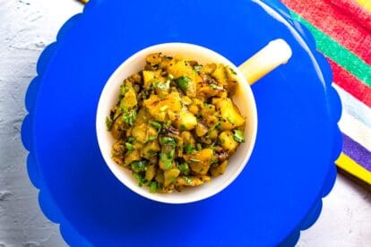 Horizontal image of Low FODMAP Grilled Pineapple & Kiwi Salsa in round handled dish on blue tray