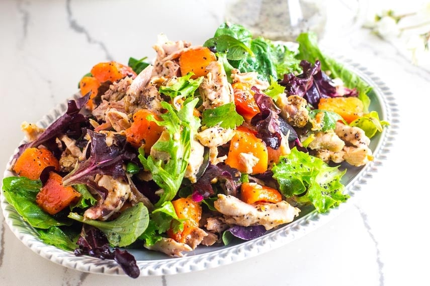 Low FODMAP Chicken Papaya Salad with Poppy Seed Dressing on oval platter; marble surface