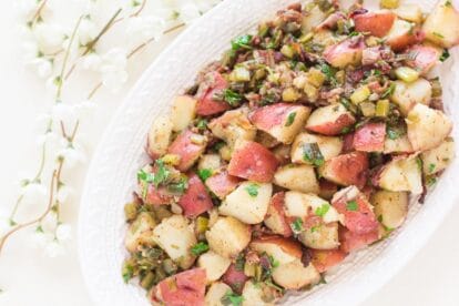 Low FODMAP Hot Potato Salad with bacon on decorative oval white platter