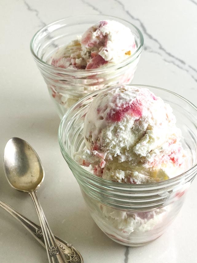 clear cups of low FODMAP Rhubarb Crumble Ice Cream with silver spoons on white marble