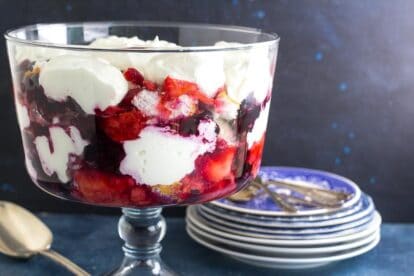 closeup of Low FODMAP Red, White & Blue Trifle in clear glass trifle bowl; blue background with blue plates