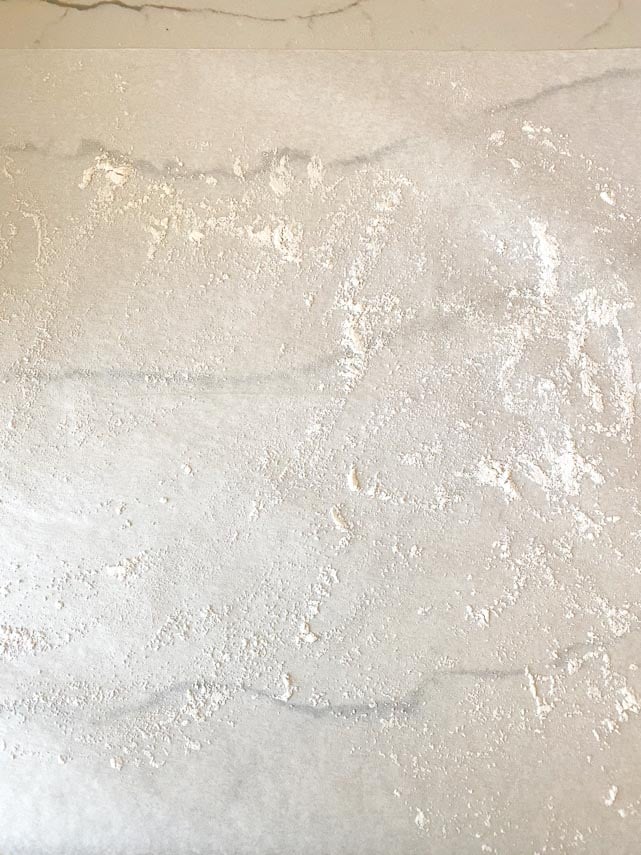 lightly flour dusted parchment paper ready for rolling our dough