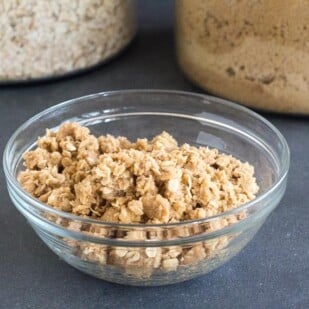 looking down into a bowl of vegan low FODMAP crisp topping in a glass bowl on a dark surface