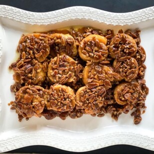 overhead low FODMAP gluten-free caramel pecan sticky buns on decorative white platter