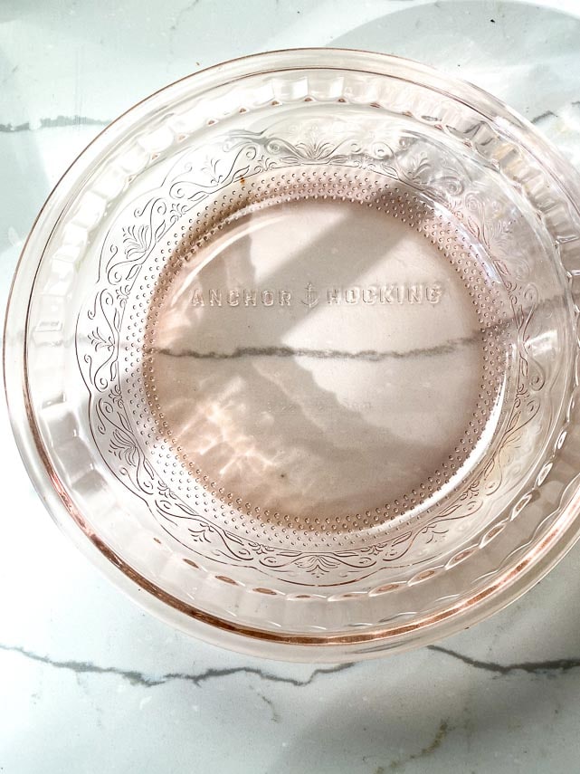 pink anchor hocking deep dish pie plate on marble surface