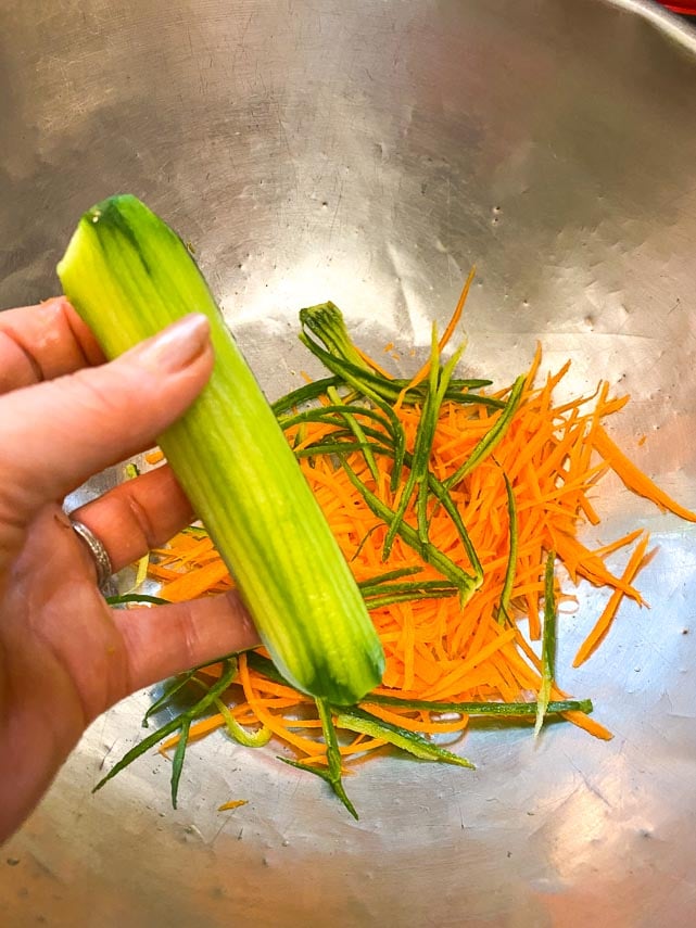 prepping carrot and cucumber for Thai basil Salad