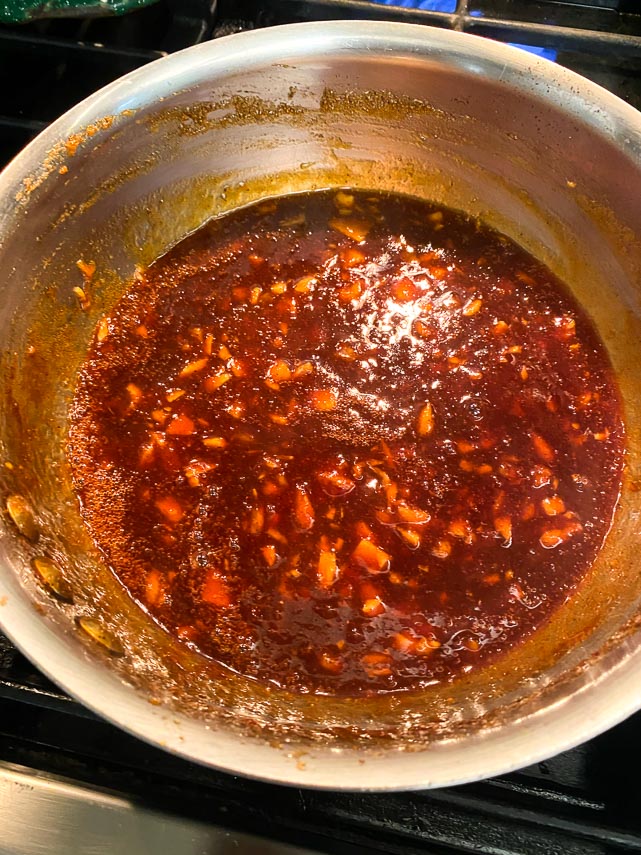 Ingredients for Low FODMAP Pineapple Whiskey BBQ sauce in pot, combined and simmering