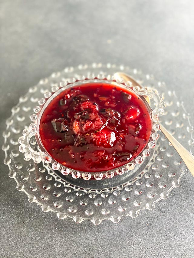 Low FODMAP Blackberry Peach Chutney in a decorative antique clear glass bowl on grey surface
