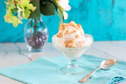 Small glass dish of low FODMAP banana coconut sorbet with silver spoon and aqua napkin