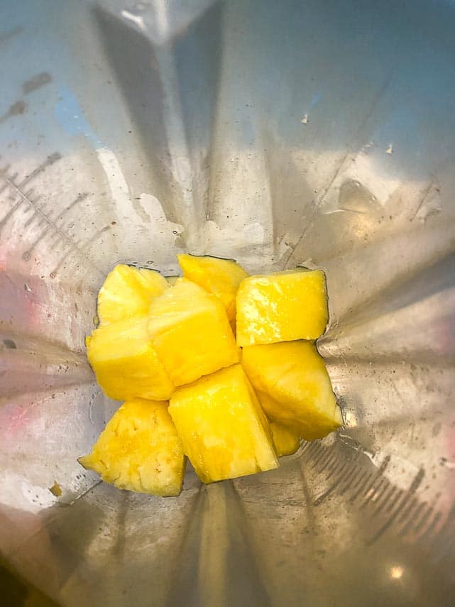 chunks of pineapple in a blender carafe