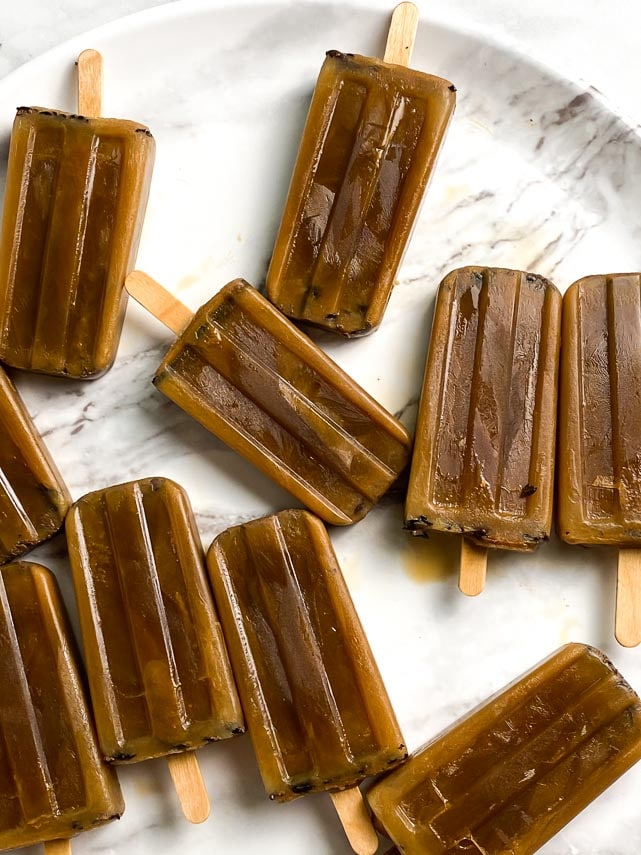 closeup of low FODMAP Cold Brew Latte Pops on round white marble tray