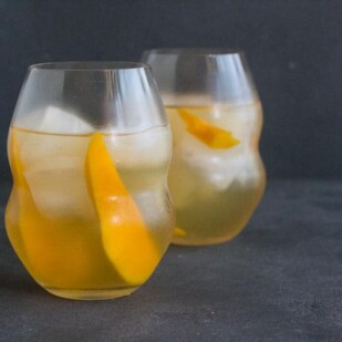 horizontal image of low FODMAP Iced White Tea with Mango in decorative clear glasses on dark background