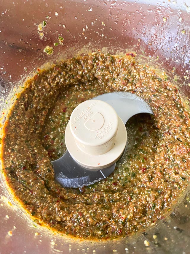 ingredients for low FODMAP sundried tomato pesto in bowl of food processor, oil added and blended