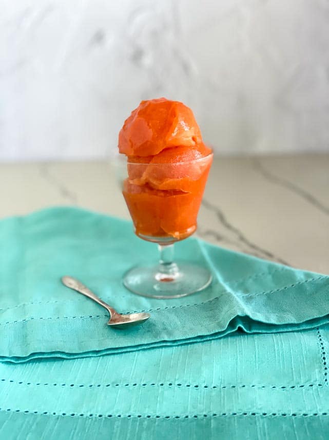 low FODMAP Papaya Lime Sorbet in small footed glass dish with aqua napkin