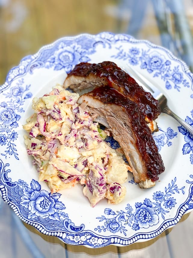 low FODMAP Pineapple Whiskey BBQ Ribs on blue and white plate with potato slaw