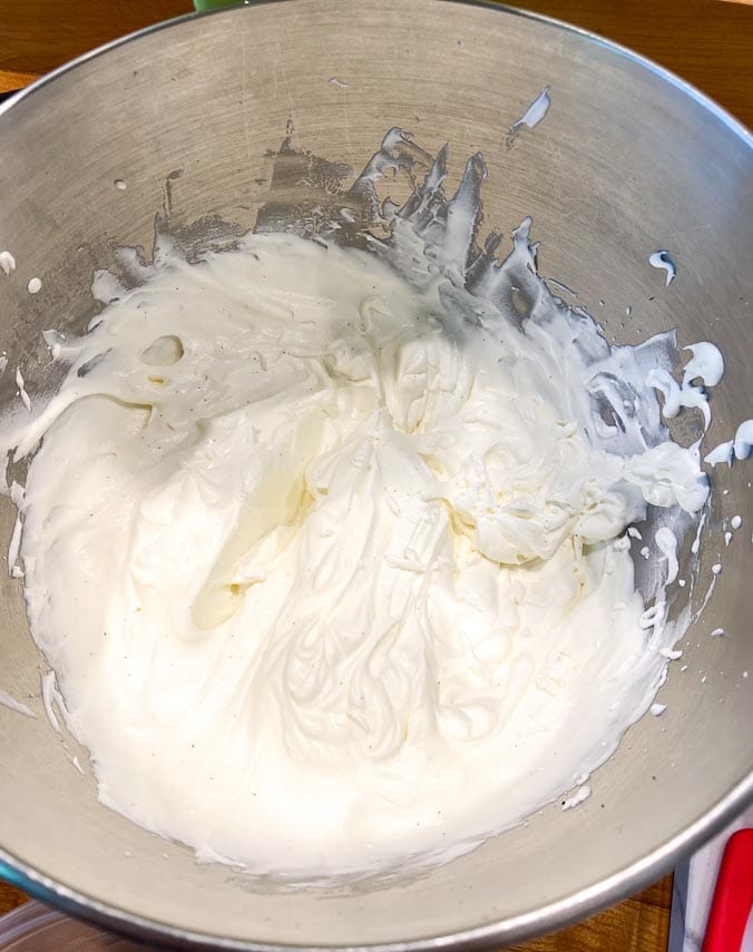 softly whipped cream in a stainless steel bowl