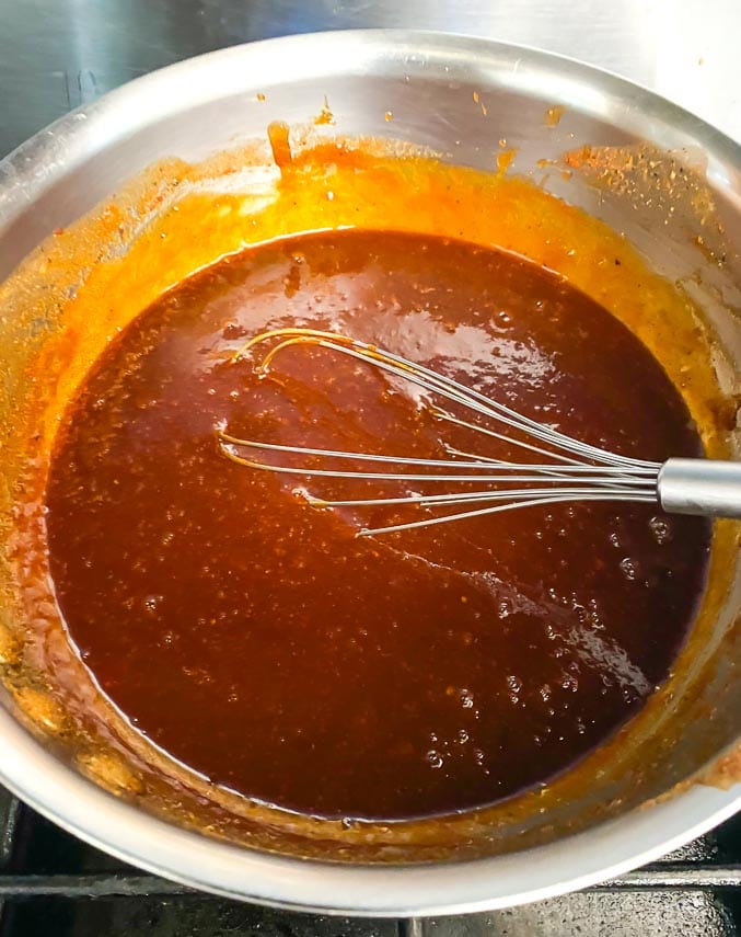 sweet and sticky BBQ sauce simmering in pan with whisk